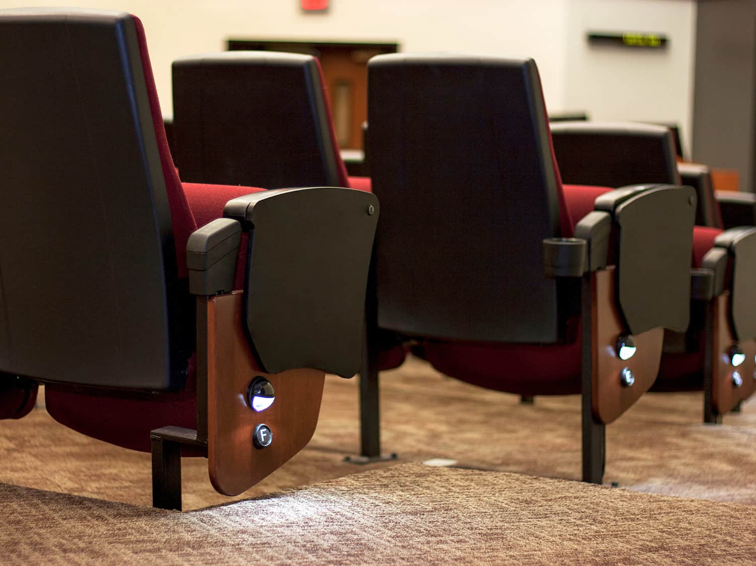 Clarity Auditorium Seating installed in a lecture hall, showing aisle light and row identification